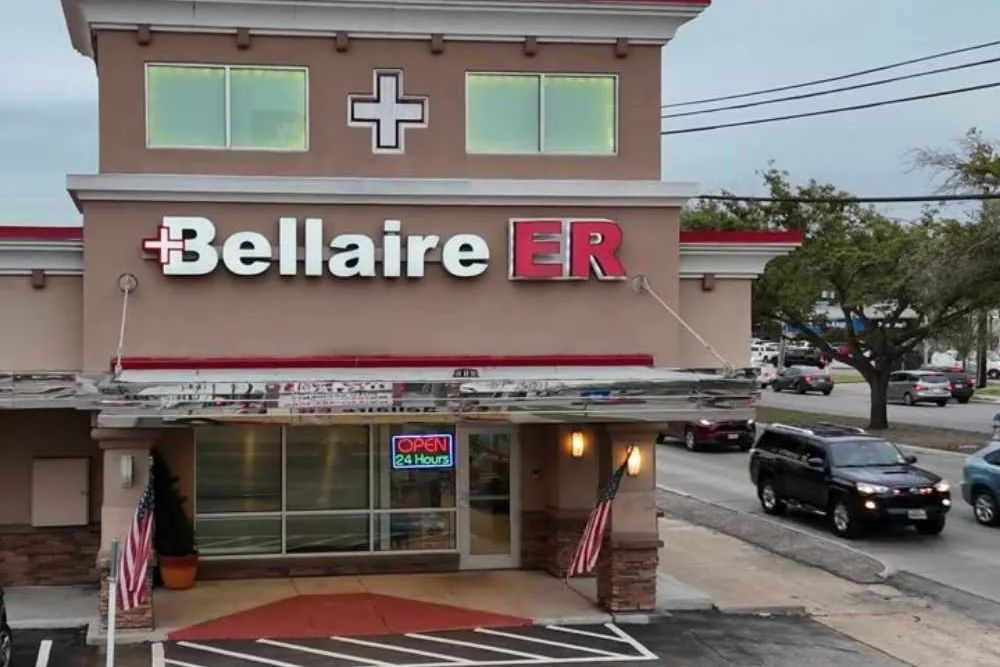 Bellaire ER facility with Open 24 Hours sign and American flags at the entrance